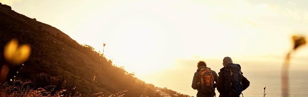 Zwei Wanderer an der Küste während Sonnenuntergang