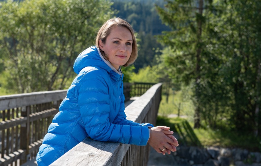 Magdalena Neuer steht auf einer Holzbrücke im Grünen und schaut in die Ferne.